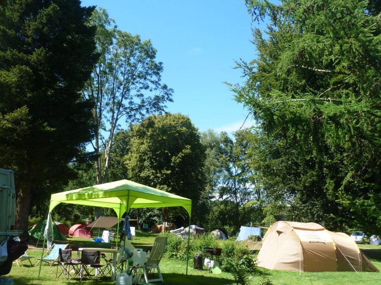 campement avec tente, table et chaises au camping