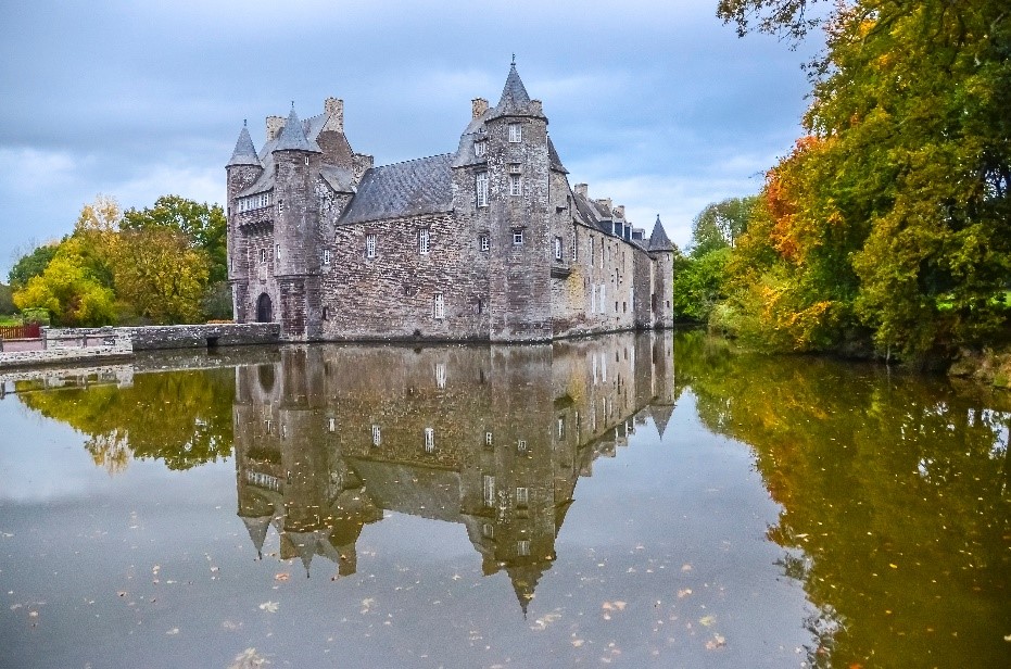 Le château de Trécesson se reflétant sur le lac.